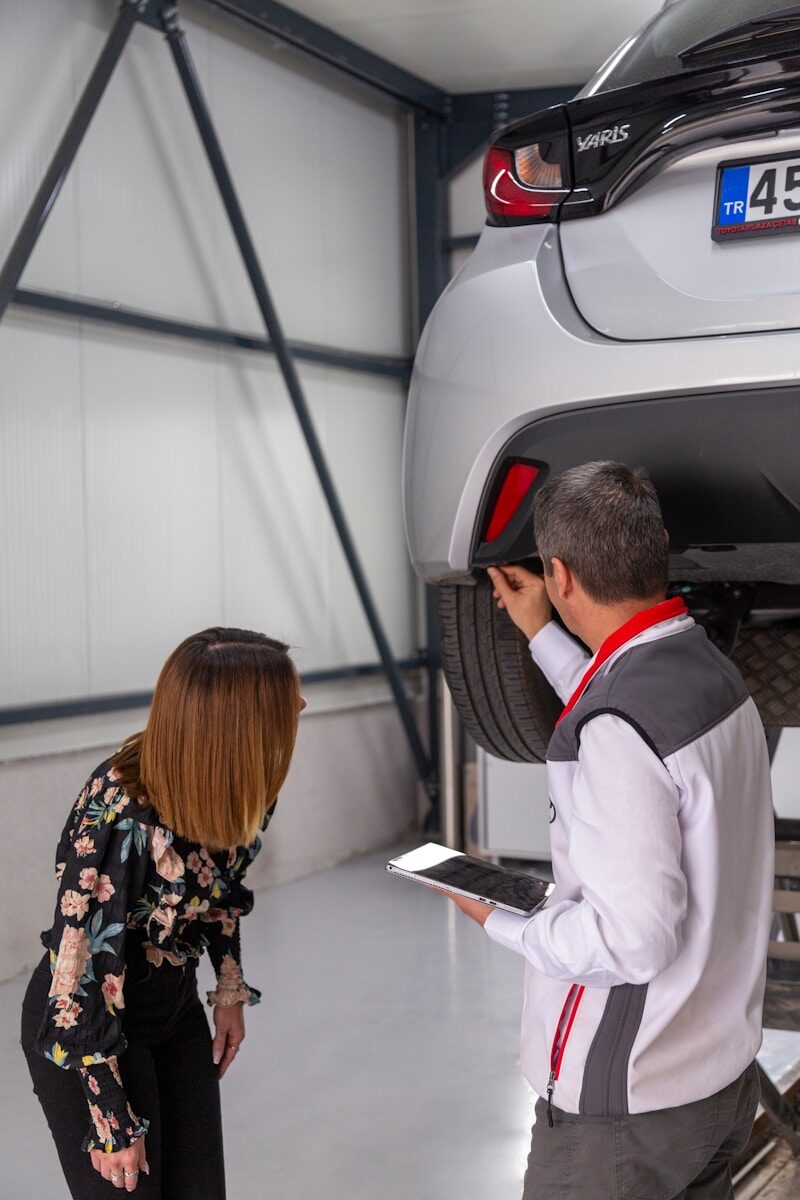 A man and a woman looking under a car A man and a woman looking under a car
