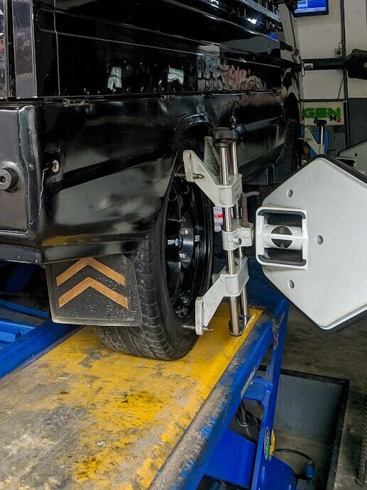 a black truck is being worked on in a garage