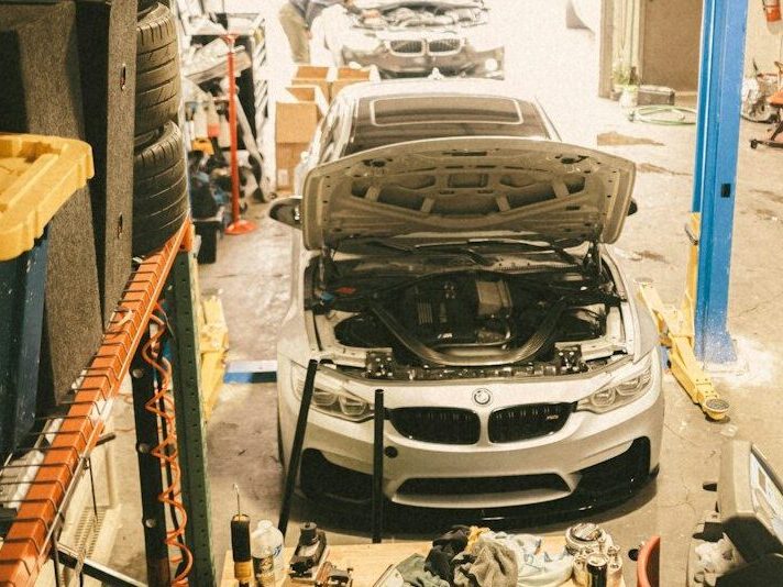 a car in a garage being worked on by a mechanic
